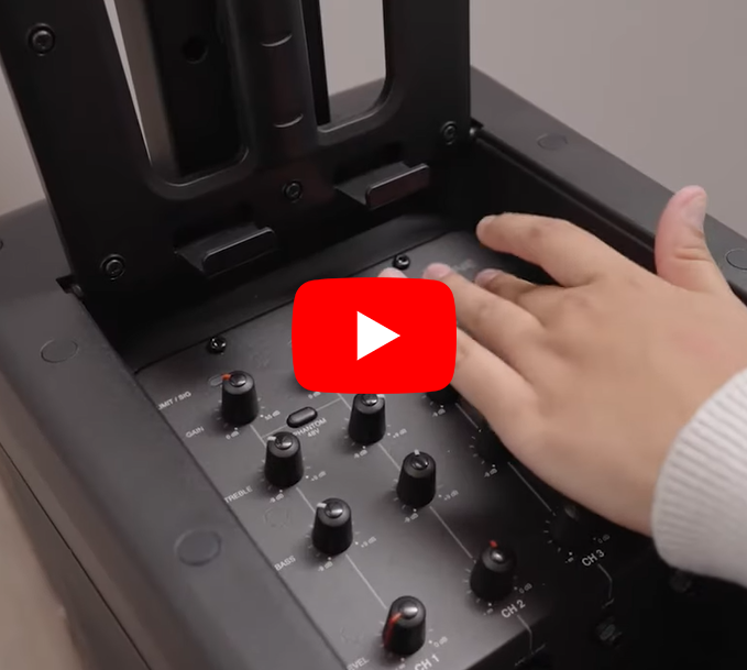 A hand manages the JBL IRX ONE Portable PA's controls.